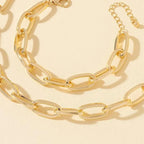 Parure de bijoux dorée de style punk avec grosse chaîne.